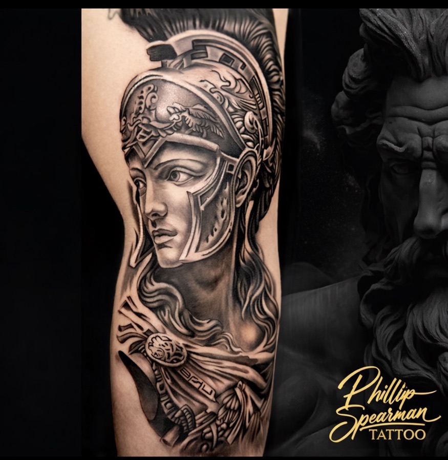 This striking black and grey portrait of Athena finds its home on the leg. The intricate details of her helmet's crest, paired with the gentle flow of her hair and drapery, showcase a profound sense of strength. It is always compelling when a piece so beautifully reflects inner resolve and grace.