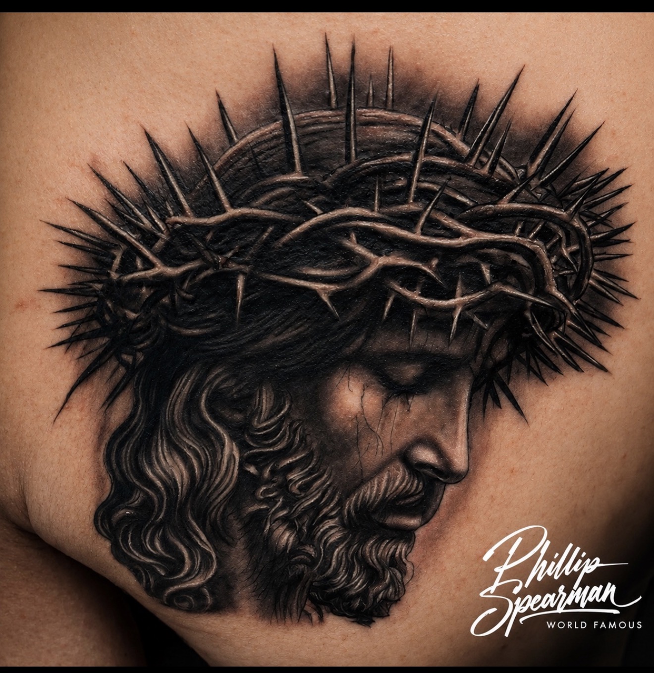 This profound black and grey portrait captures Yeshua in a moment of serene contemplation, crowned with meticulously rendered thorns. The intricate textures within his hair and beard lend a timeless quality to the realism, beautifully composed to embrace the natural form of the body. It’s a powerful piece where light and shadow eloquently tell the story.