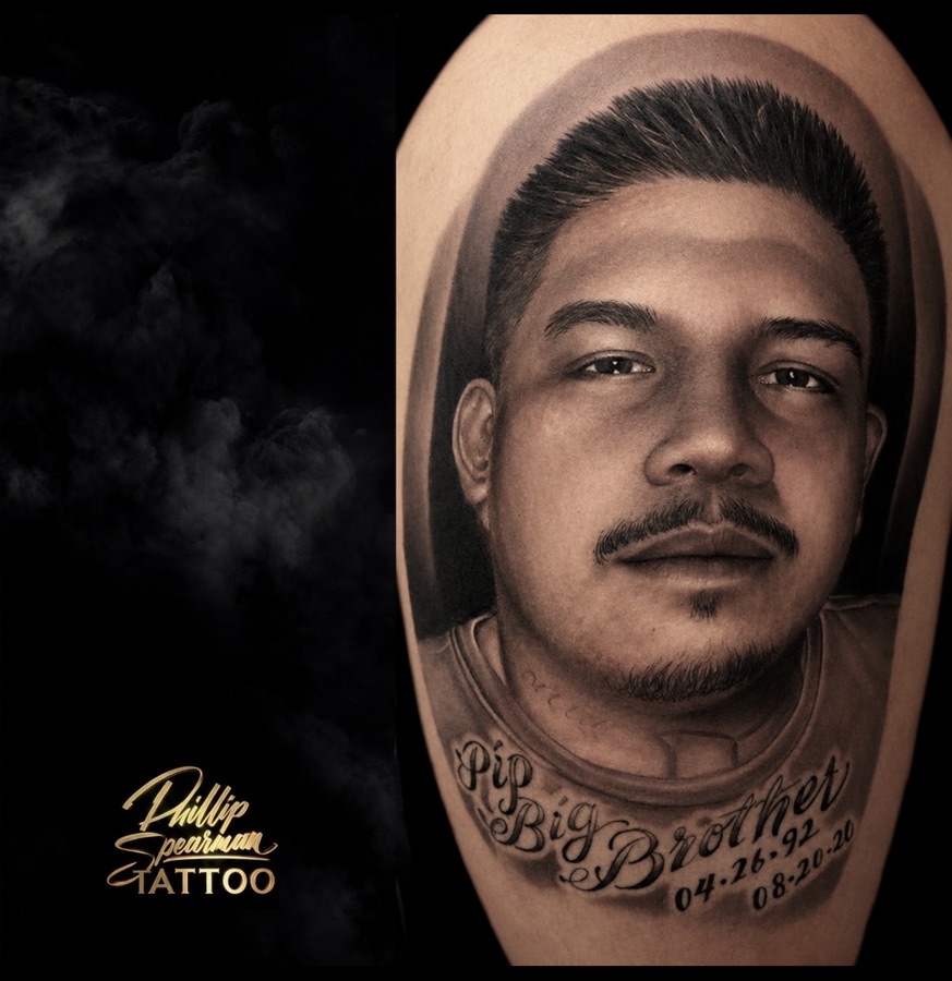 This deeply moving portrait beautifully honors a loved brother, captured with thoughtful precision in black and grey. The nuanced shading brings a lifelike quality to the facial expression, ensuring his memory is kept close and personal on the arm. Below the portrait, the delicate script 'Pip Big Brother' alongside significant dates adds a final, heartfelt layer to this enduring tribute.