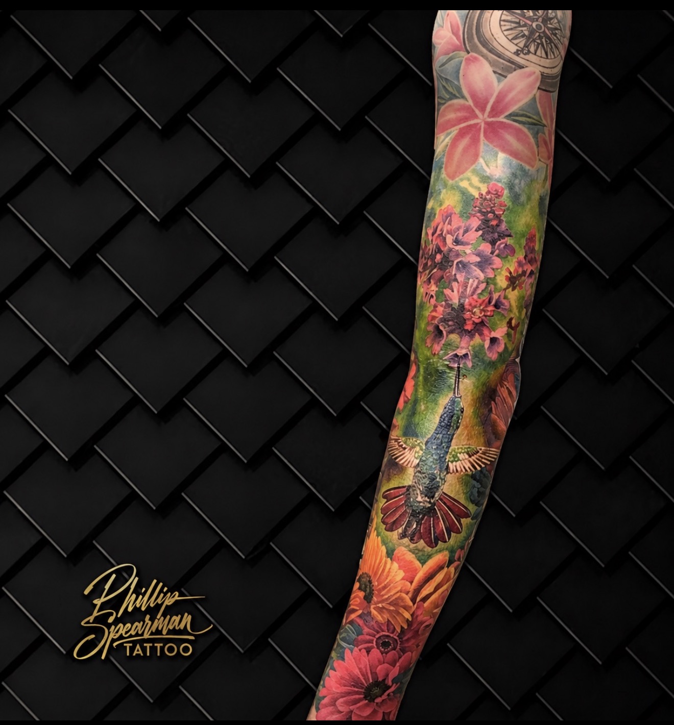 This vibrant color sleeve brings a lively garden scene to life, featuring a brilliant hummingbird poised among a field of lush, colorful flowers. The deep, rich hues and intricate layering create a sense of depth, with each petal and feather rendered in exquisite detail across the arm. It’s a joyful and natural immersion.