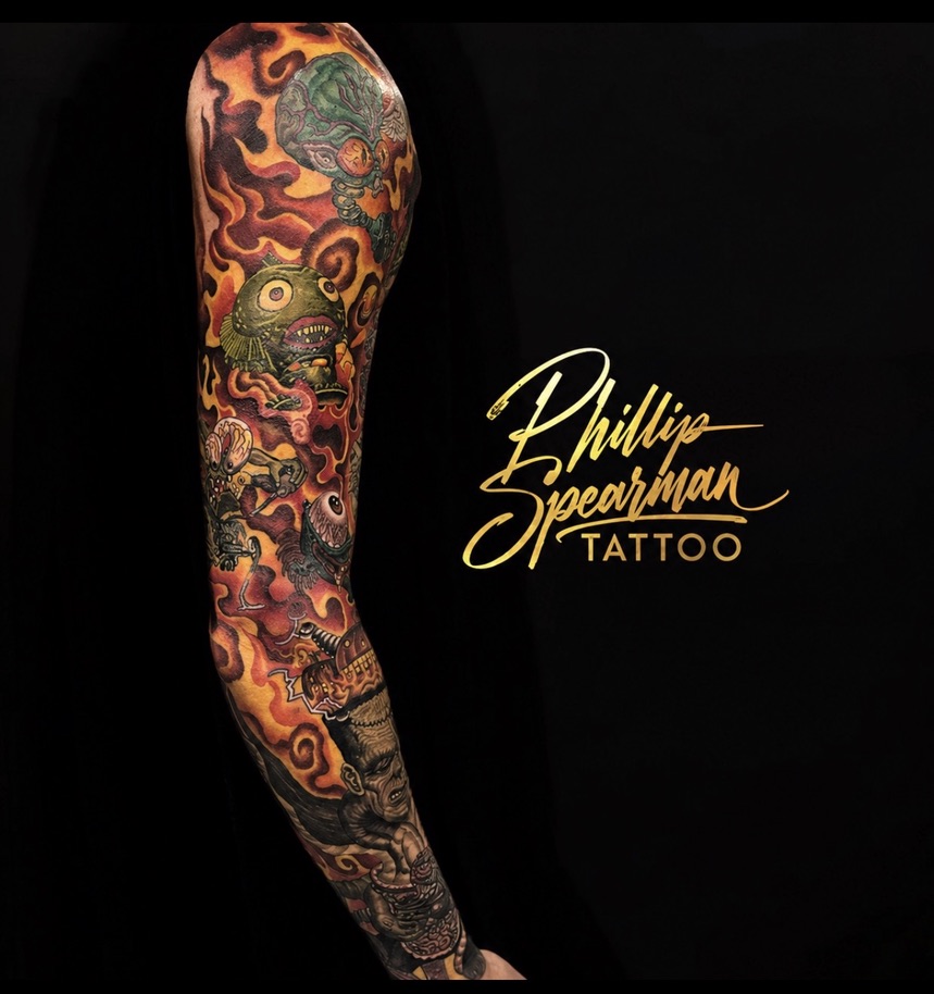 This vibrant full sleeve ignites the arm with a dynamic world of creatures, each emerging from a backdrop of intricate, flame-like energy. With artistic freedom as his guide, Phillip layered rich colors and complex textures—from the subtle scales on the central creature to the fiery patterns—to create a piece that authentically embodies the client's character. The entire composition flows seamlessly, holding a powerful narrative around the arm.