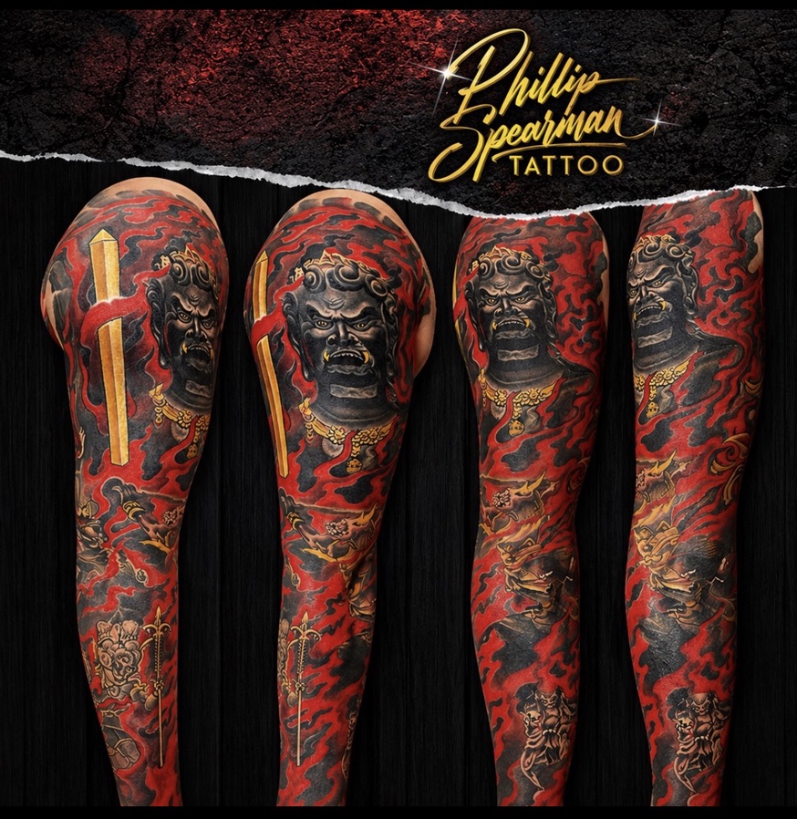 This powerful Japanese Fudo Myoo full color sleeve beautifully captures a rich narrative. Fudo Myoo, depicted here watching over realms, is surrounded by dynamic red and black flames, creating a striking contrast with his dark, resolute form and the bright golden embellishments. Below, five smaller, intricate demons are seamlessly woven into the composition, representing internal struggles contained within the overall flow of the sleeve.