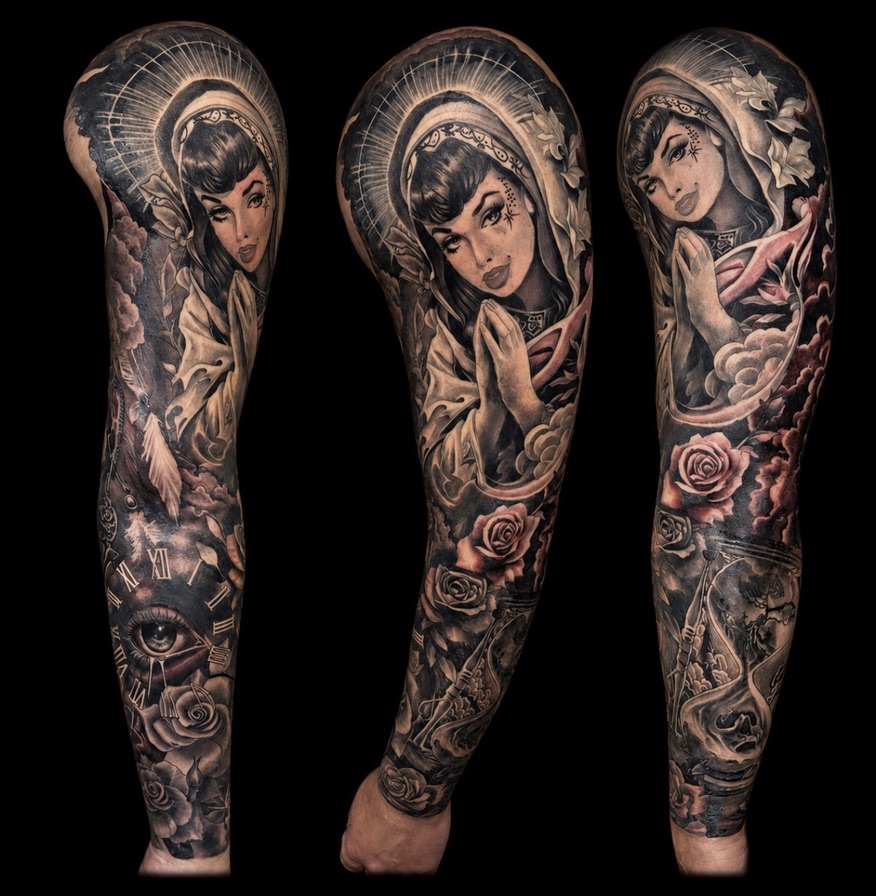 This black and grey sleeve beautifully brings together a rich tapestry of classic and contemporary elements. At the shoulder, a rockabilly Virgin Mary anchors the piece with her praying hands and halo, her striking gaze drawing you into the narrative that flows down the arm. Below, the theme of time unfolds with the sands of time, featuring a tree of life gracefully emptying into the glass of death, culminating in a detailed clock face with a poignant eye, all softly accented with blooming roses throughout.